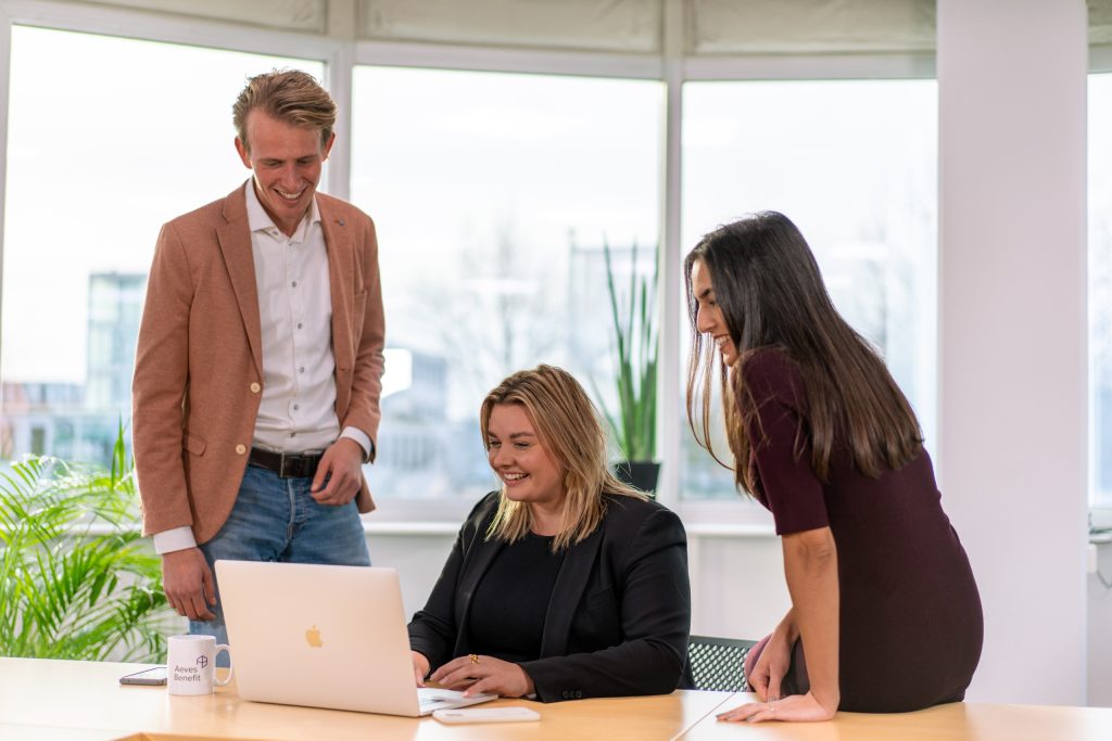 Onze drie recruiters verzamelt rond een laptop, klaar om jouw vragen te beantwoorden. Neem contact op!